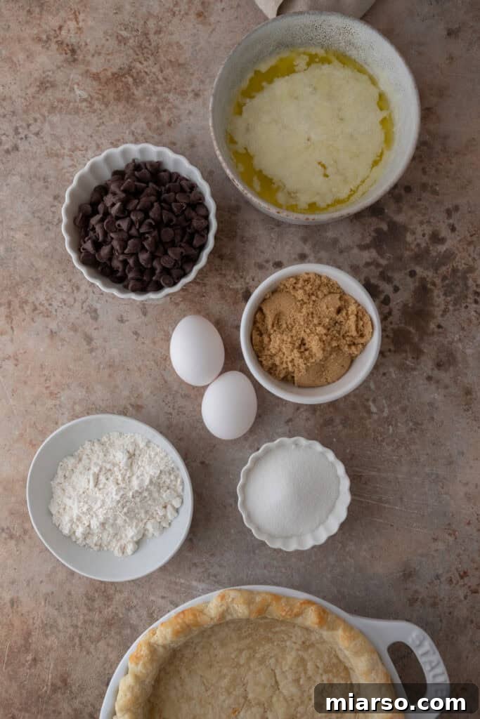 chocolate chip cookie pie recipe ingredients laid out, including flour, sugars, eggs, butter, and chocolate chips