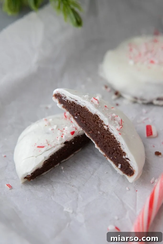 Irresistible Peppermint Bark Cookies 2 Half-split peppermint bark cookies showcasing the fudgy chocolate base, creamy white chocolate, and vibrant candy cane pieces.