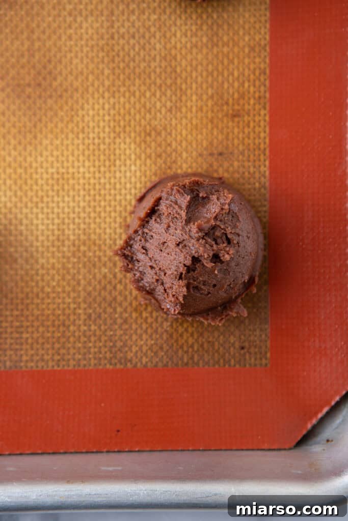 Irresistible Peppermint Bark Cookies 9 Scooped cookie dough balls on a baking sheet.