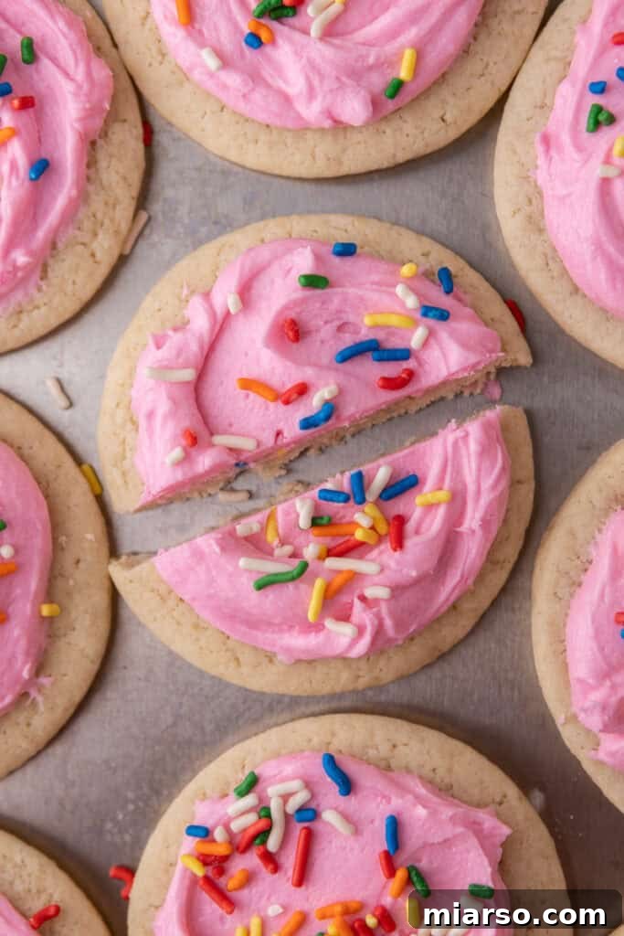 Soft and Fluffy Sour Cream Sugar Cookies 14 An inviting image of soft, frosted sour cream sugar cookies, perfectly sliced in half to clearly display their incredibly tender and fluffy texture on the inside.