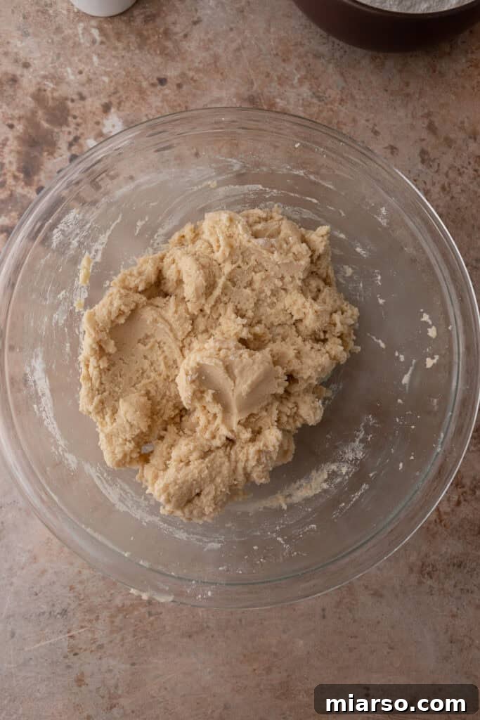 Soft and Fluffy Sour Cream Sugar Cookies 7 A perfectly mixed, smooth, and cohesive cookie dough resting in a clear glass bowl, showcasing its readiness for chilling and subsequent rolling and cutting.
