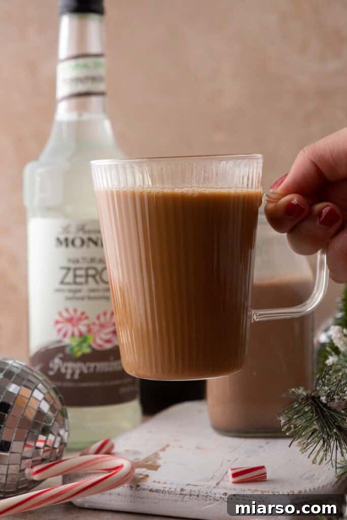 The Ultimate DIY Peppermint Mocha Creamer 4 Hand holding a mug with Peppermint Mocha Creamer coffee