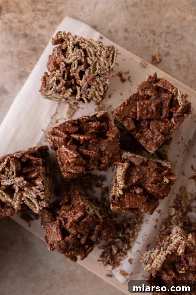 Irresistible Muddy Buddy Bars 11 chocolate cereal squares on a parchment paper