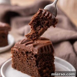 A slice of Sourdough Discard Chocolate Cake with a fork, emphasizing its delightful texture and taste.