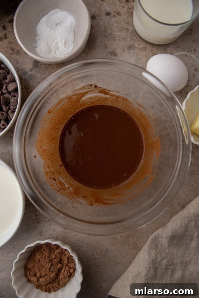 Hot coffee and cocoa powder being whisked together in a bowl to bloom the cocoa.