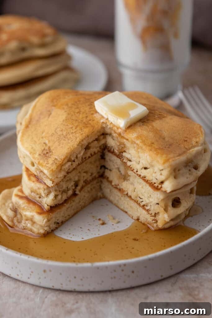 Beautifully stacked fluffy sourdough discard pancakes drizzled with maple syrup