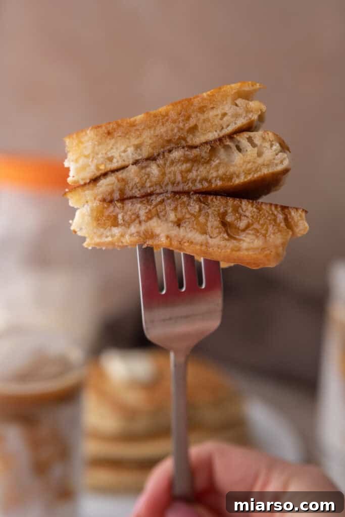 Sourdough discard pancake on a fork, showing its fluffy texture