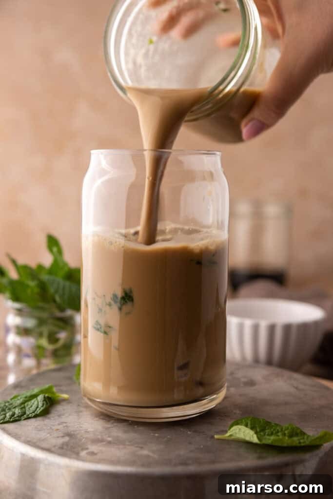 DIY Phylz Mint Mojito Iced Coffee 11 Hand pouring mojito iced coffee in a cup full of ice