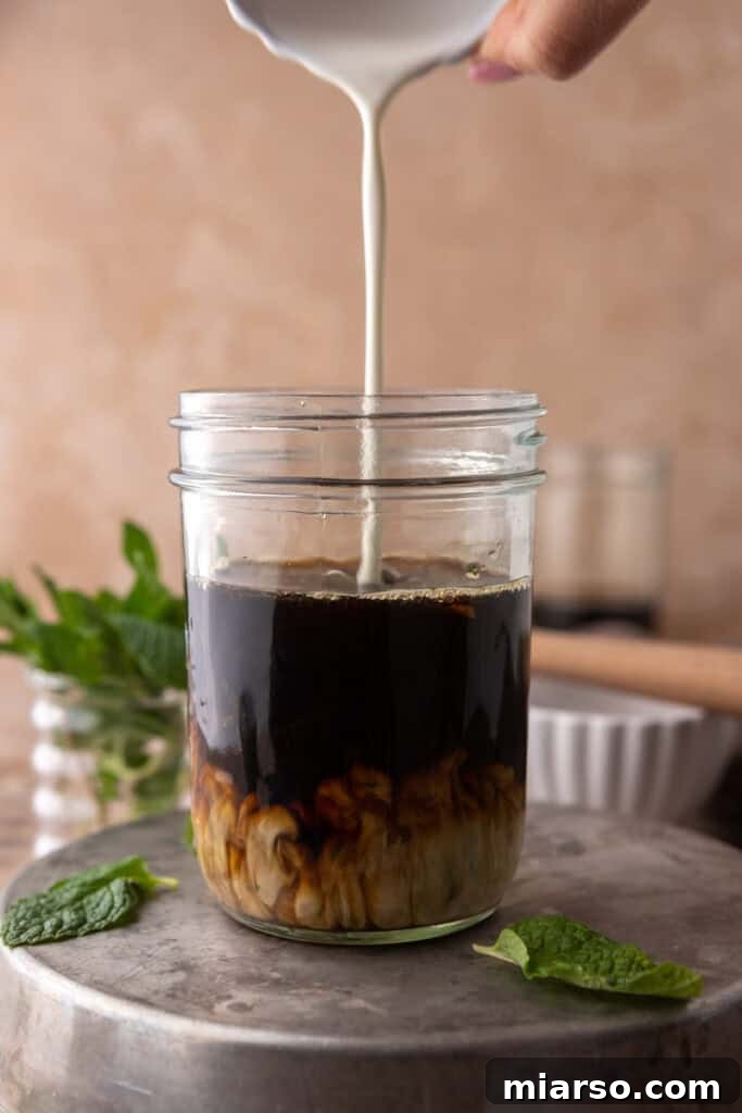 DIY Phylz Mint Mojito Iced Coffee 9 Hand pouring cream in a cup of coffee