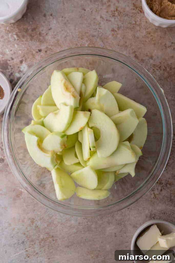 Effortless Apple Filling for Delicious Desserts 5 Freshly peeled and chopped apples in a bowl, ready for cooking.