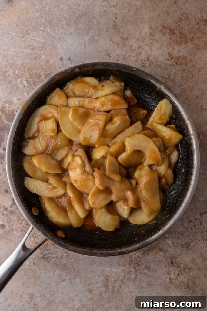 Effortless Apple Filling for Delicious Desserts 10 Thickened apple filling simmering in a pot, showcasing its rich, saucy texture.