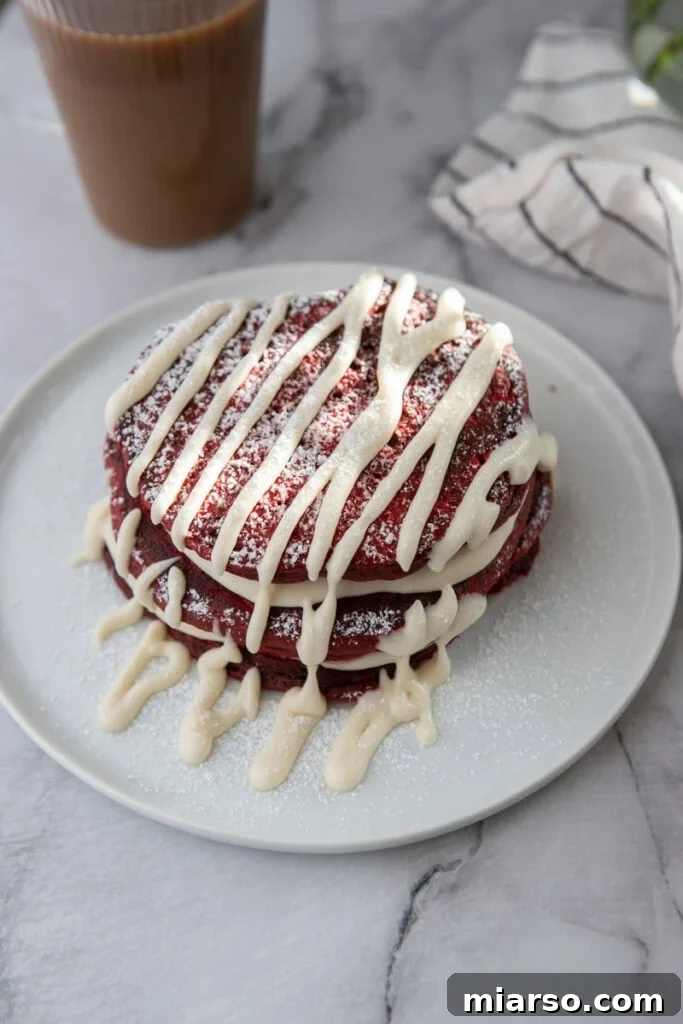 Indulgent Red Velvet Pancakes 10 A close-up shot of a single Red Velvet Pancake on a fork, showing its fluffy texture and moist interior, with a hint of cream cheese glaze.