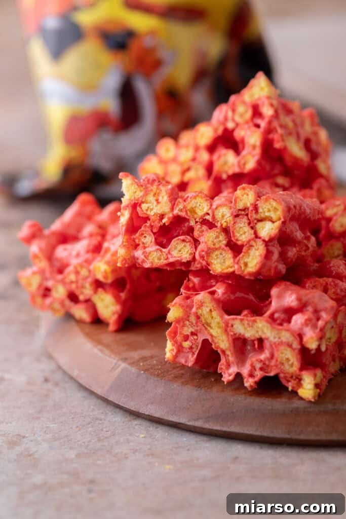 Overhead shot of Hot Cheetos Marshmallow Crispy Treats cut into squares on a plate.