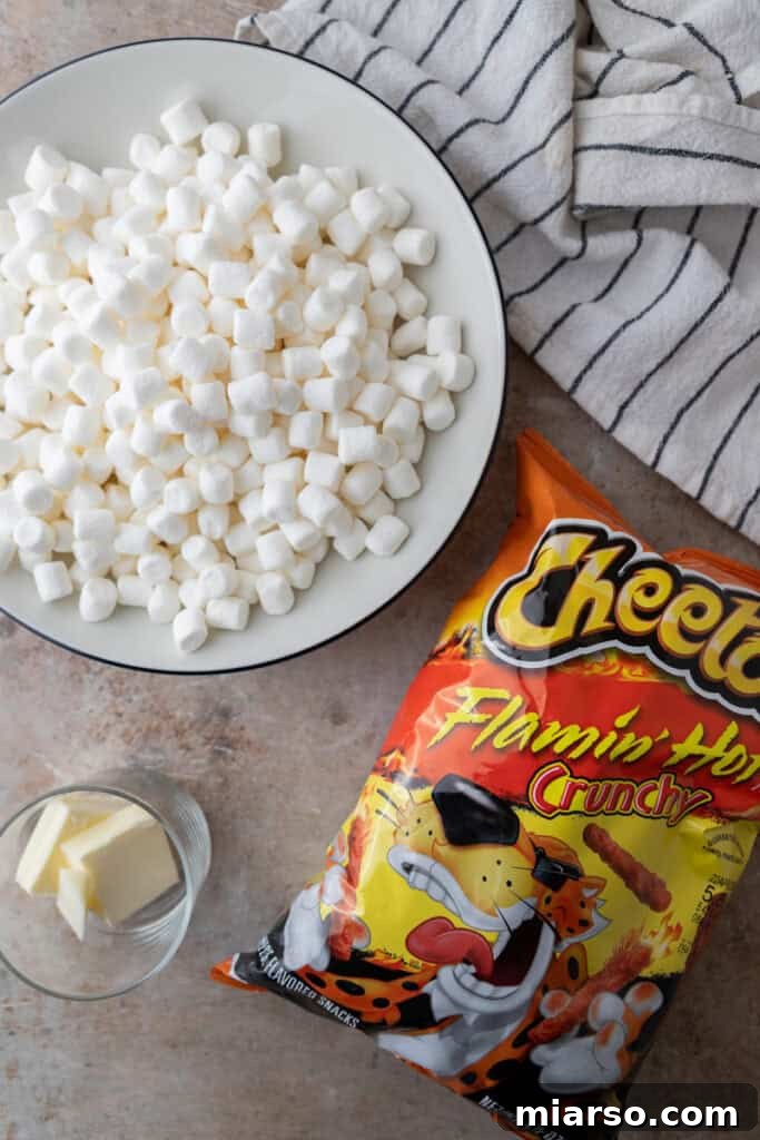 Ingredients for Hot Cheetos Marshmallow Crispy Treats laid out: a bag of Flamin' Hot Cheetos, butter, and miniature marshmallows.