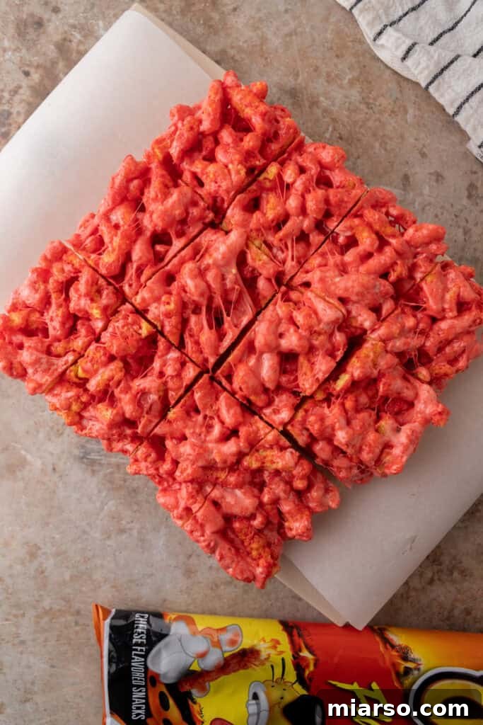 Sliced Hot Cheetos Marshmallow Crispy Treats on a cutting board.