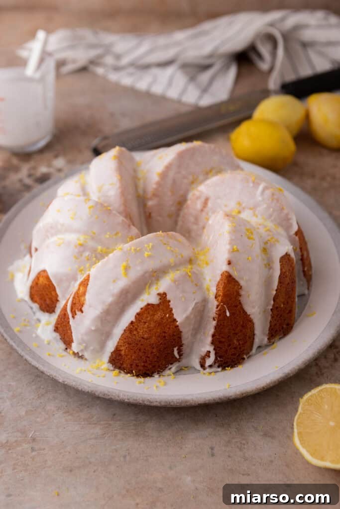 A fully iced lemon bundt cake with glaze dripping down the sides