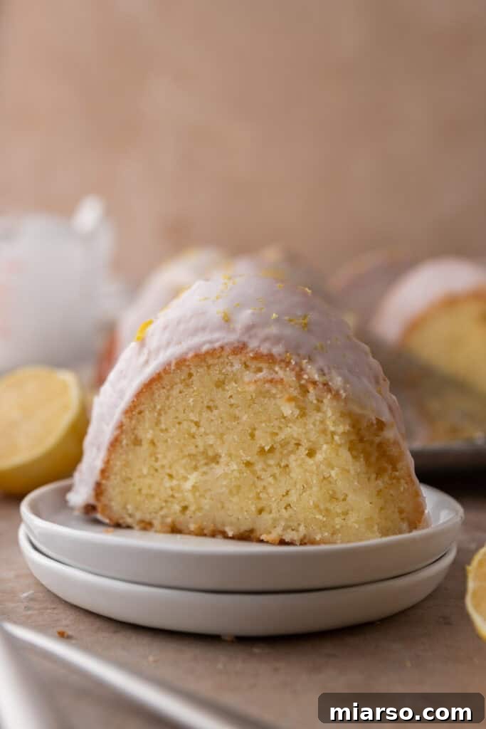 A beautiful slice of the moist lemon bundt cake on a white plate