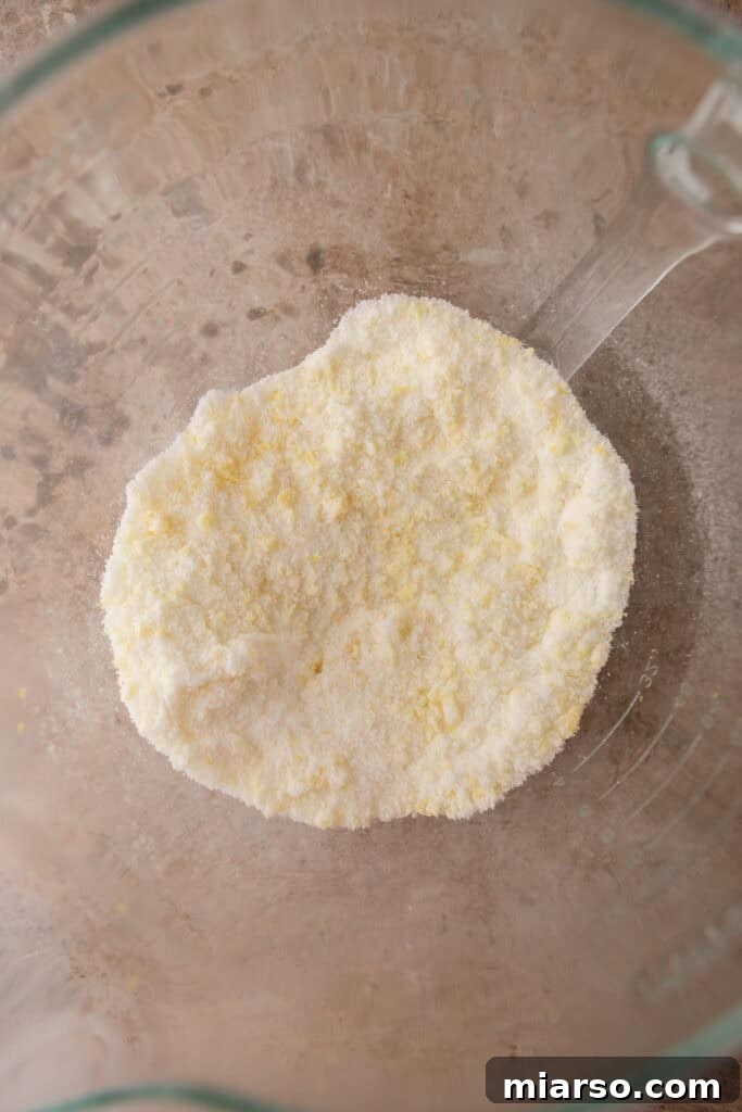 Sugar and lemon zest being rubbed together