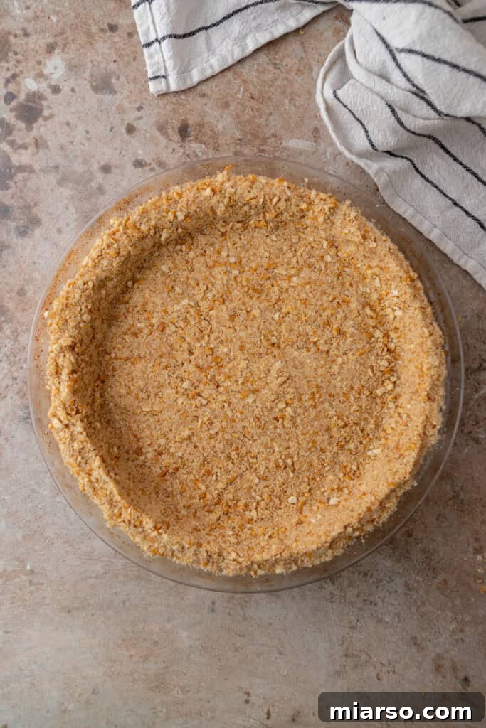 Ultimate Pretzel Pie Crust 11 Overhead shot of a pretzel pie crust in a dish with a pie server ready to lift a slice.