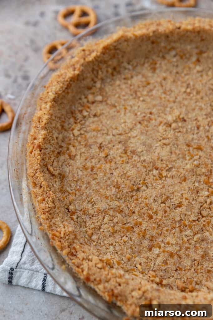 Ultimate Pretzel Pie Crust 10 Overhead shot of a slice of pie with pretzel crust on a white plate.
