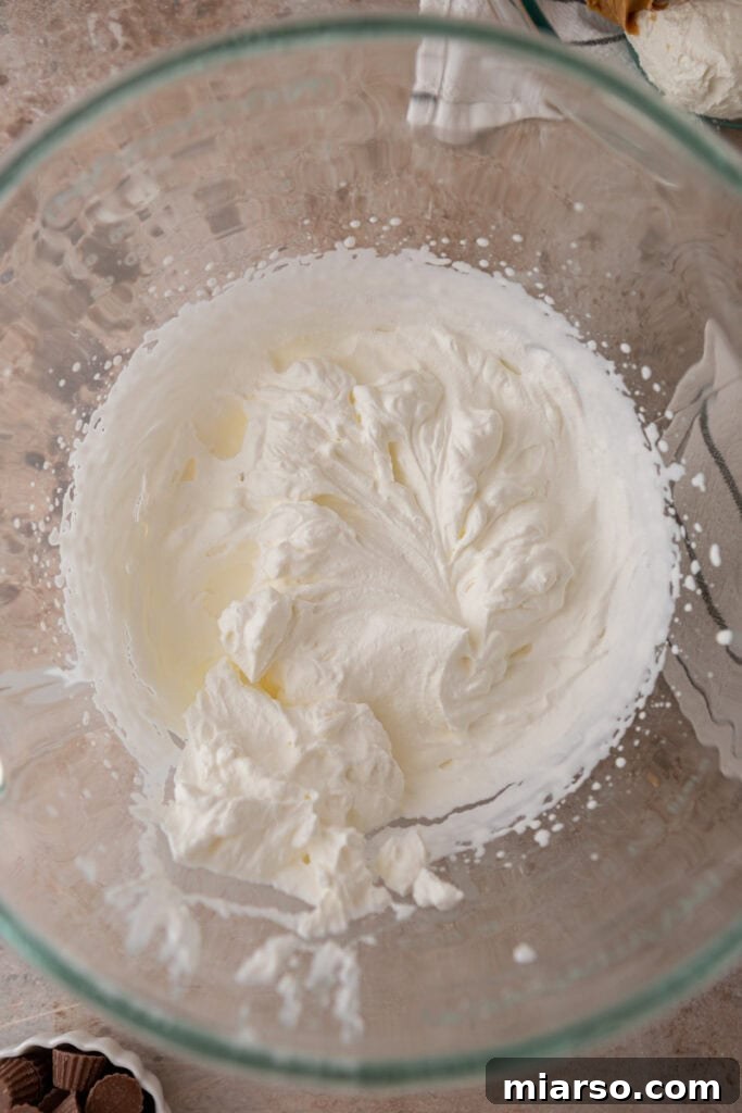Cream cheese and peanut butter partially mixed in a bowl, showing the initial stages of combining.