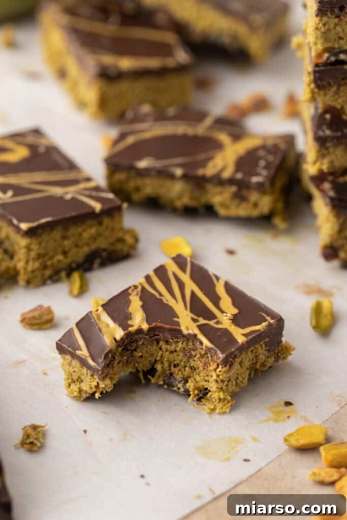 A single piece of Dubai Chocolate Date Bark held up, showing its defined layers.