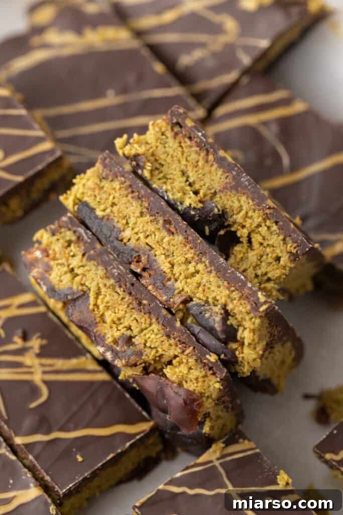 Several pieces of Dubai Chocolate Date Bark neatly stacked, showcasing the chocolate topping and pistachio filling.