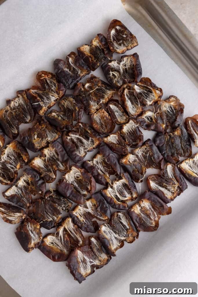 Melted chocolate being poured over the pistachio and date layers.