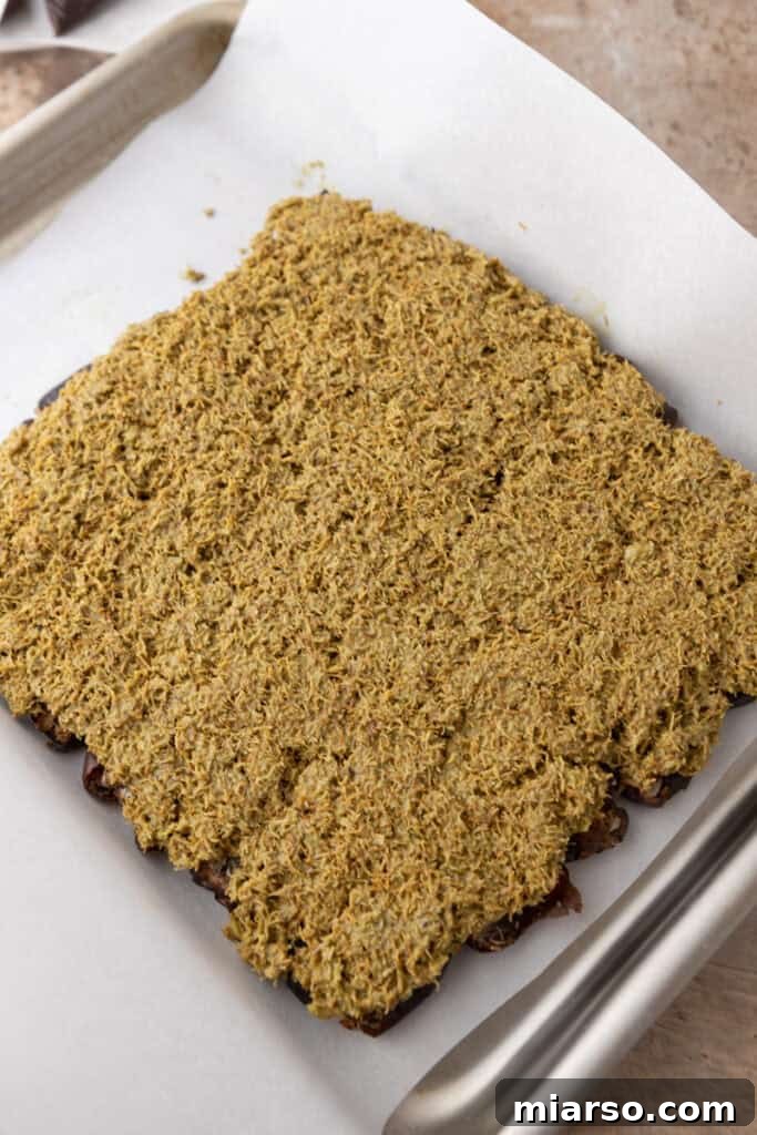 The chocolate layer being spread smoothly over the bark, ready for chilling.