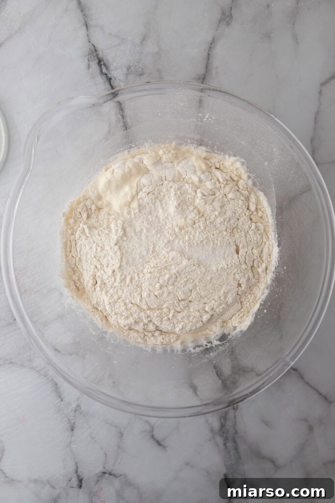 Elevate Your Baking Perfect Sourdough Croissant Bread 7 flour, starter and water in a bowl together