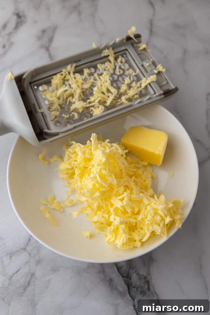 Elevate Your Baking Perfect Sourdough Croissant Bread 9 butter being grated into a bowl