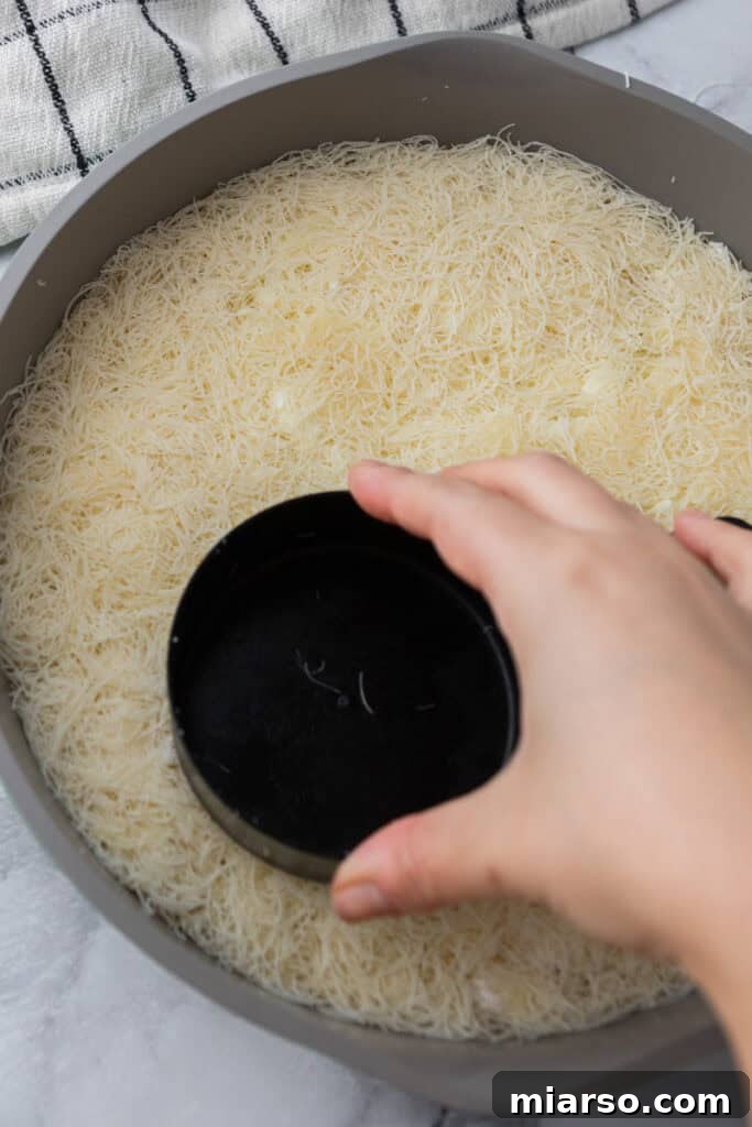 dough and cheese in a pan being pressed down