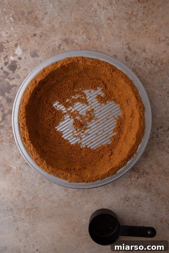 The Secret to a Perfect Biscoff Pie Crust 12 ingredients being pressed into a pan