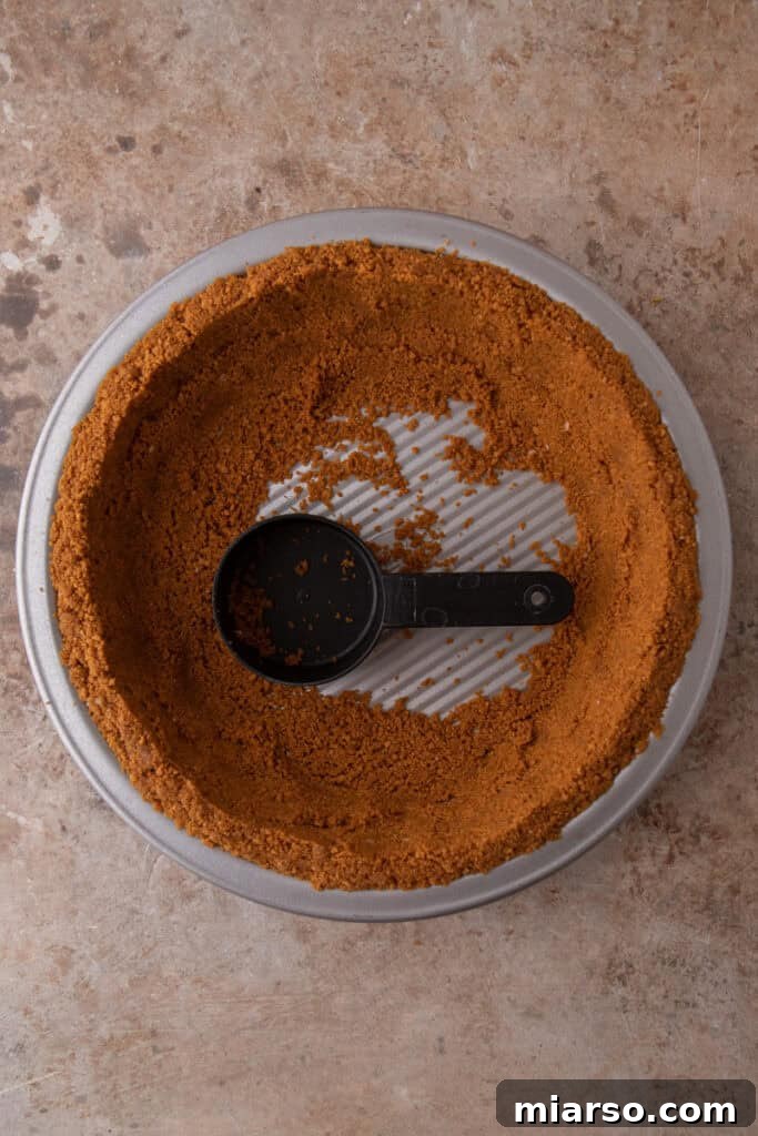 The Secret to a Perfect Biscoff Pie Crust 8 ingredients being pressed into a pan
