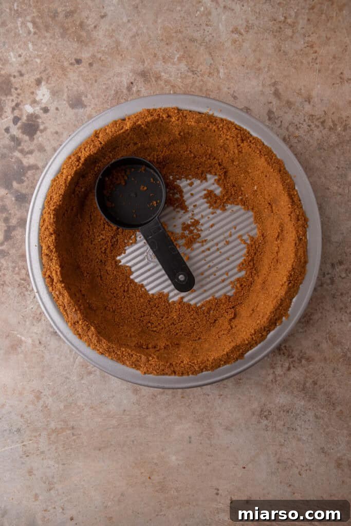 The Secret to a Perfect Biscoff Pie Crust 9 ingredients being pressed into a pan