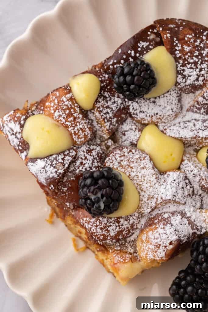 A single, perfectly baked slice of Pretzel French Toast Casserole elegantly presented on a pristine white plate, garnished and ready to be savored.