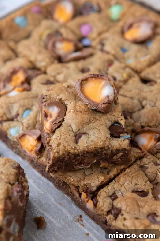 A close-up shot of a Cadbury Egg Chocolate Chip Easter Cookie Bar on a wooden surface.
