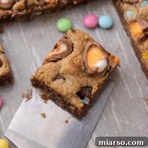 A single Cadbury Egg Chocolate Chip Easter Cookie Bar being lifted by a spatula, ready to be enjoyed.