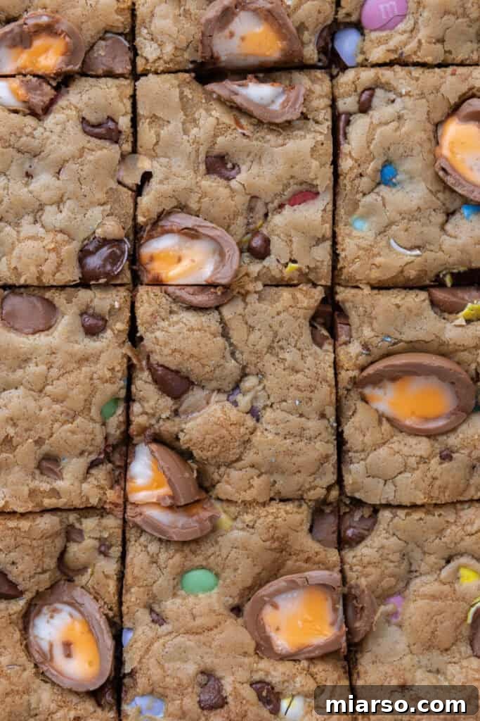 A close-up shot of a finished Cadbury Egg Chocolate Chip Easter Cookie Bar, showing the embedded M&M's and Cadbury eggs.