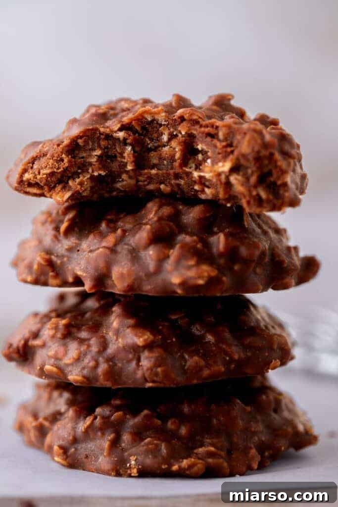 Decadent No Bake Chocolate Oatmeal Treats 4 Stacked No-Bake Chocolate Oatmeal Cookies with a sprinkle of cocoa powder