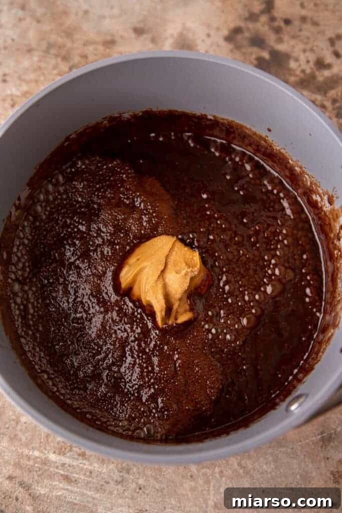 Decadent No Bake Chocolate Oatmeal Treats 6 Boiling wet ingredients for no-bake cookies in a saucepan