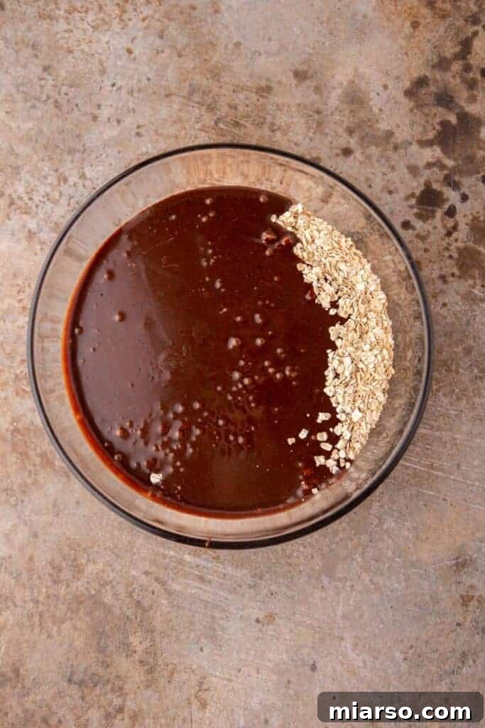 Decadent No Bake Chocolate Oatmeal Treats 7 Oats being mixed into the chocolate and butter mixture in a saucepan