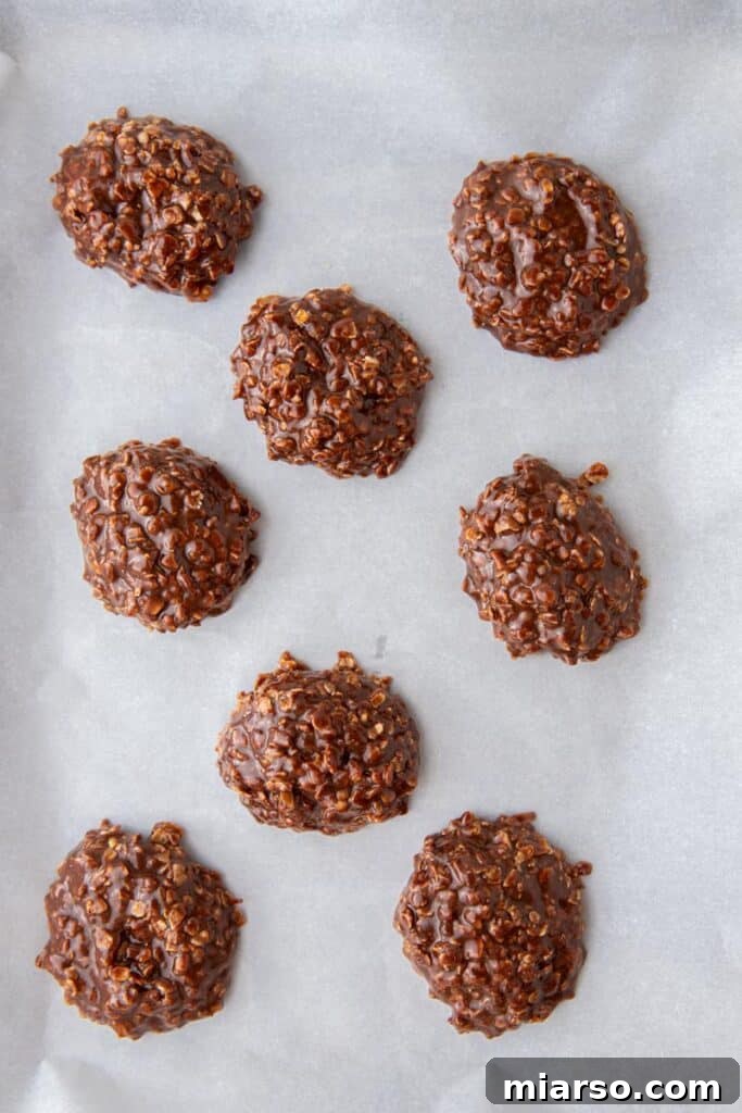 Decadent No Bake Chocolate Oatmeal Treats 9 Freshly scooped no-bake chocolate oatmeal cookies on a sheet pan