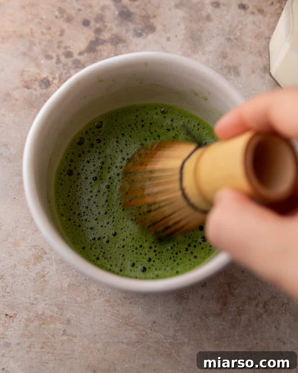 Whisked matcha being mixed until smooth and foamy
