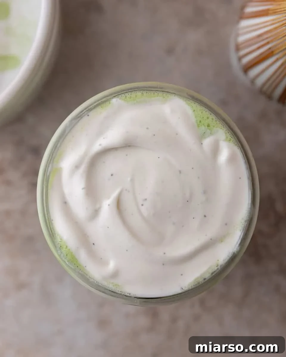 Creamy cold foam on top of a matcha latte
