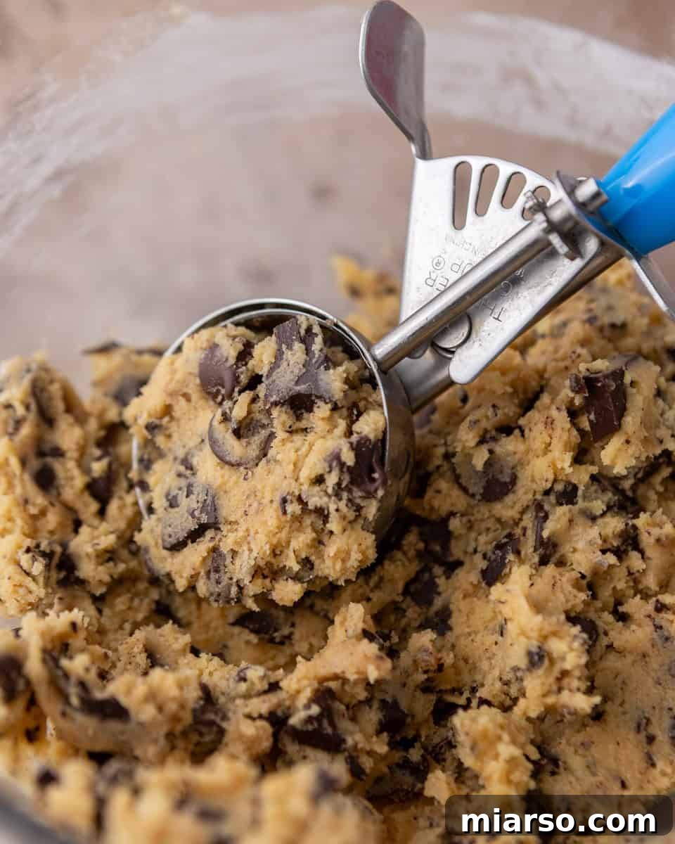 Velvety Soft Cream Cheese Chocolate Chip Cookies 8 Scooping cream cheese chocolate chip cookie dough with a cookie scoop