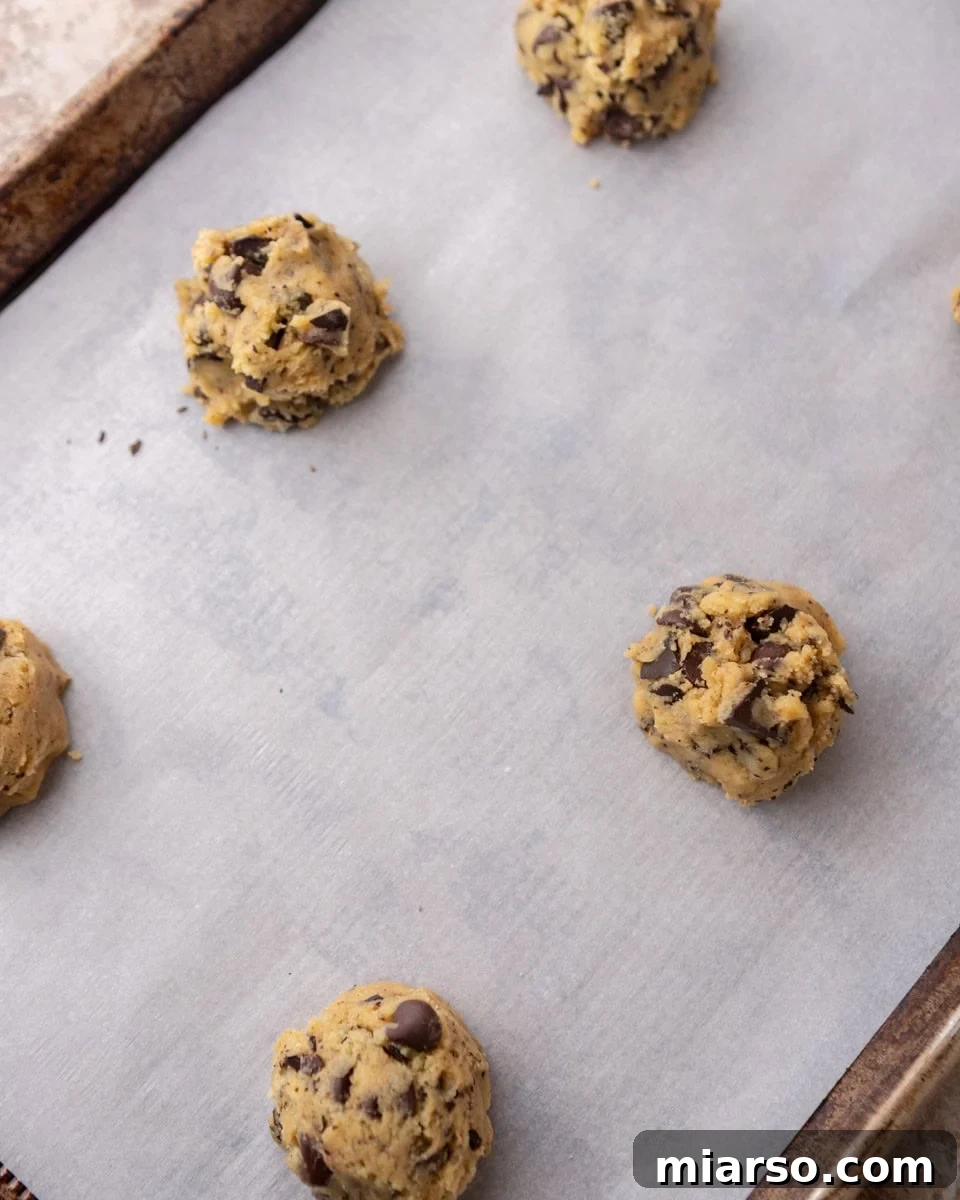 Velvety Soft Cream Cheese Chocolate Chip Cookies 9 Cream cheese cookie dough balls on parchment-lined baking sheet