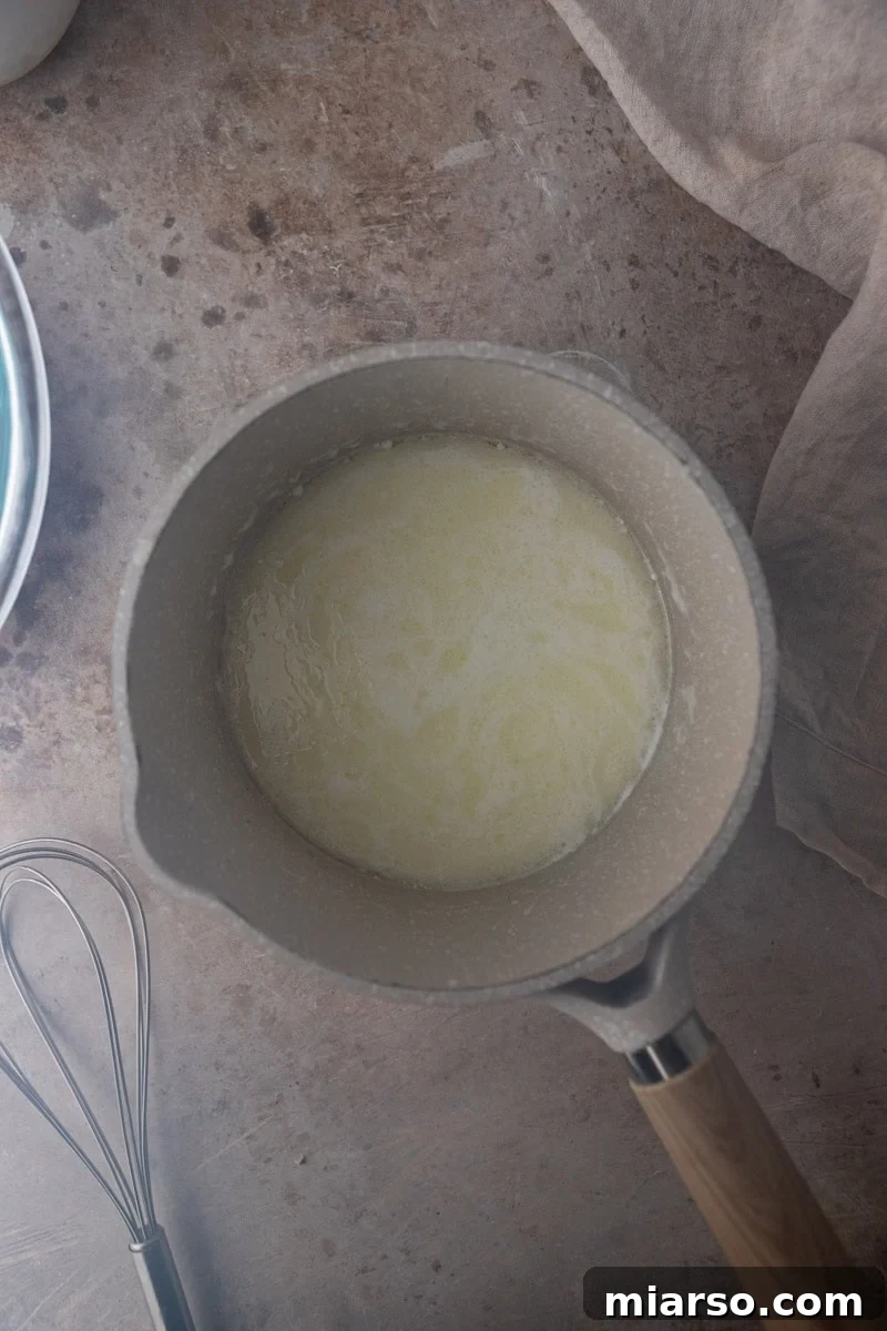 Whole milk and oil heating gently in a saucepan, the first step in preparing the pão de queijo dough.
