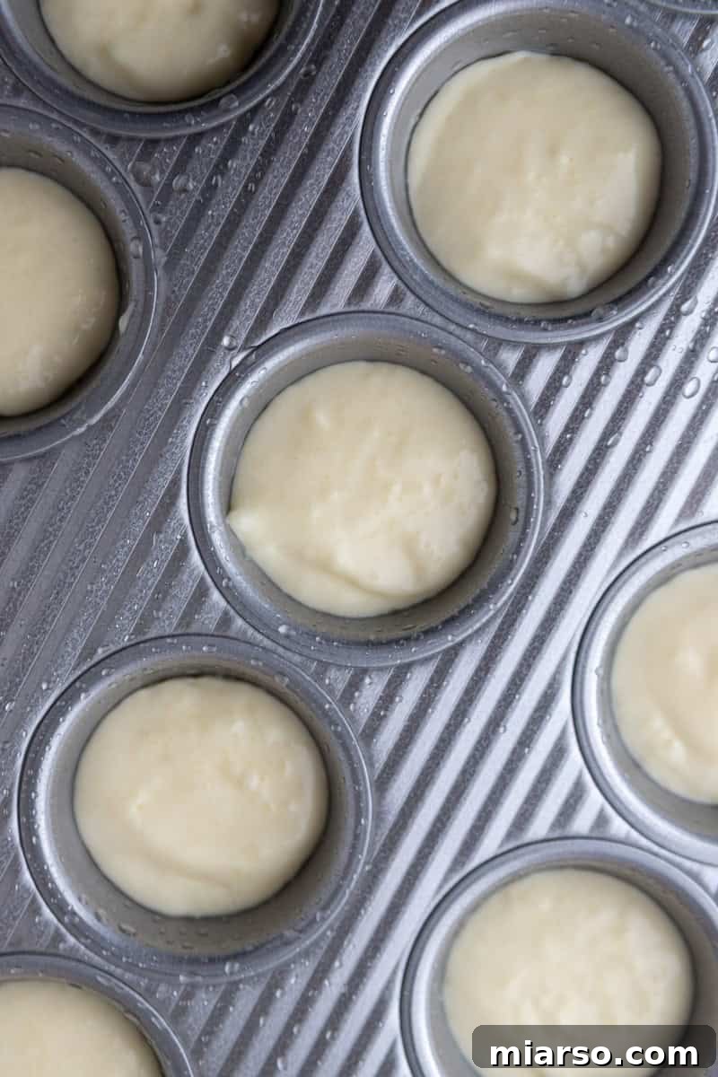 Unbaked Brazilian cheese bread batter, perfectly portioned into the mini muffin tin, ready to be transformed in the oven.