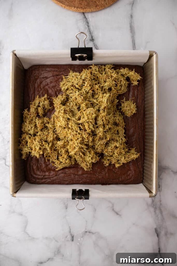 Dubai's Viral Pistachio Kunafa Brownies 17 ingredients going over other layer, showing kataifi spread on brownies